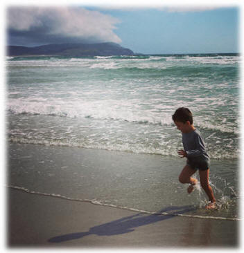 Un niño corre sobre la playa de Nemiña